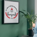 yurt yönetim odasının duvarında MEB tablosu var. Sağ tarafta bir kadın bu tabloyu işaret ediyor