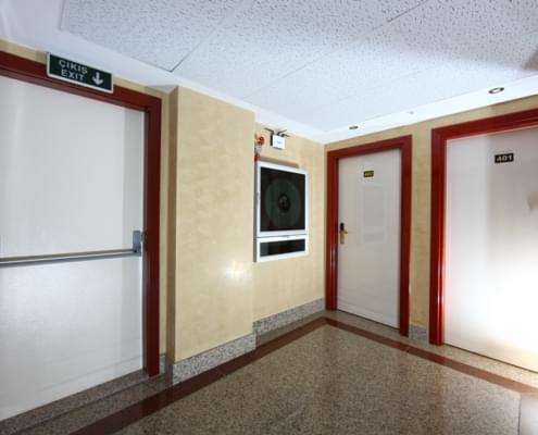 ogrenci-yurdu-yangin-cikisi Nuvola kzı öğrenci yurdu, yangın çıkışı görseli. Solda yangın çıkış kapısı, onun yanında wifi yükseltici, yangın alarmı ve yangın hortumu tertibatı. sağ karşıda 401 ve 402 numaralı odaların giriş kapıları.