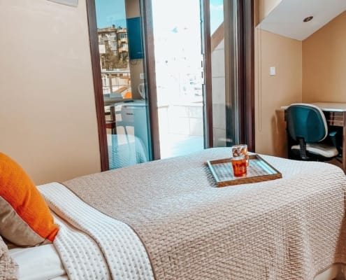 Nuvola Kız Öğrenci Yurdu Balkonlu Oda Seçeneği Nuvola Kız Öğrenci Yurdu özel odaları (bir kişilk yurt odası) otek konforunda ve bu özelliklerde bir yurt deneyimi sunuyor. Bazı odalarımızda balkon seçeneği de sunuluyor. Görselde, yatak, balkona açılan sürgülü kapı ve çalışma masası bulunuyor.