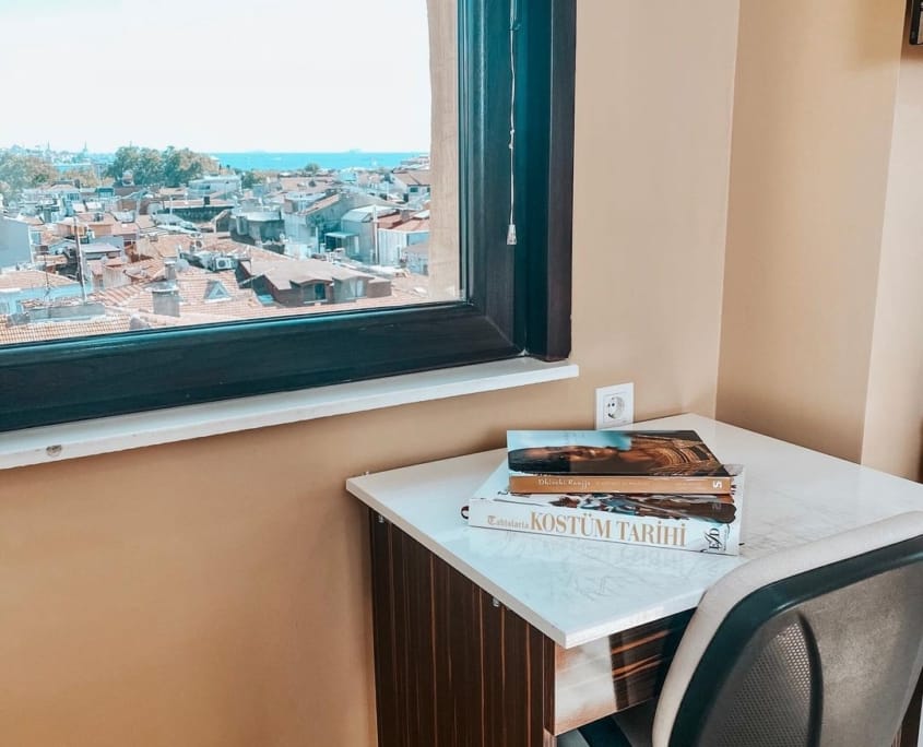 Nuvola Kız Öğrenci Yurdu Beşiktaş'ın enfes deniz manzarasına karşı ders çalışabileceğiniz bir yurt ortamı sunuyor. Fotoğrafta, deniz manzaralı odanın çalışma masası ve çalışma koltuğu yer alıyor.