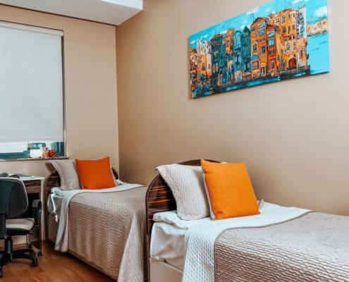 Nuvola Kız Öğrenci Yurdu Oda Seçenekleri Nuvola Kız Öğrenci Yurdu oda seçenekleri, 1, 2, 3 ve 4 kişilik odalardan oluşuyor. Odalarda kaliteli ve konforlu donanım ve yeterli ekipman yer alıyor. Görselde iki yatak, stor perde ile bir kısmı kapatılmış pencere ve çalışma masasının bir kısmı görünüyor.